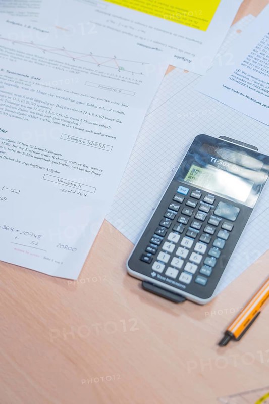 A calculator is lying on a table with mathematical documents, Jugend Forschungszentrum Nagold, Calw district, Germany