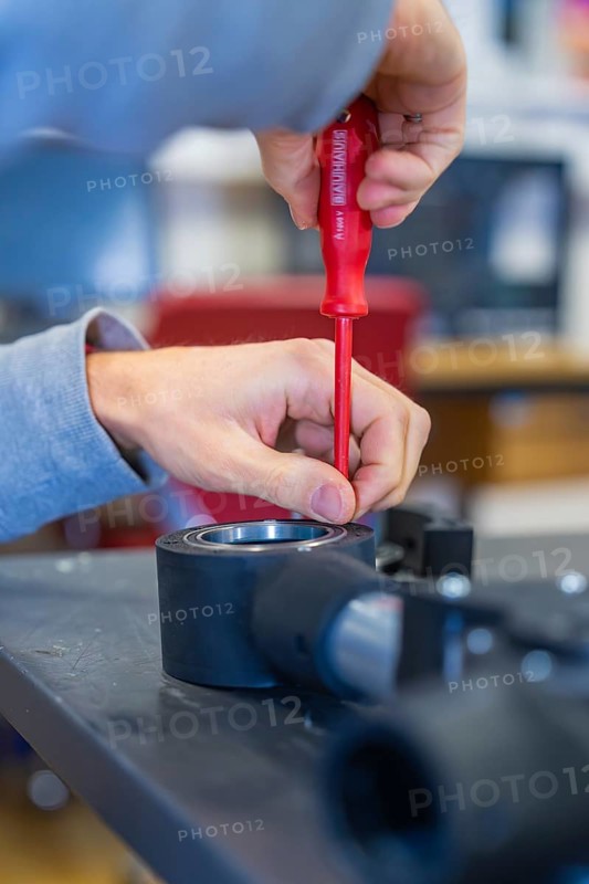 Person uses screwdriver to mount on a technical device, Jugend Forschungszentrum Nagold, Calw district, Germany