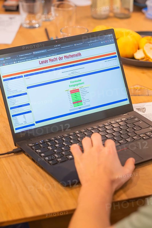 Hand operates a laptop with mathematics software on a wooden table, Jugend Forschungszentrum Nagold, Calw district, Germany