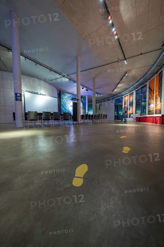 Large, modern room with yellow footprints on the floor and lighting on the ceiling, Amazonia exhibition, Gasometer, Pforzheim, Germany