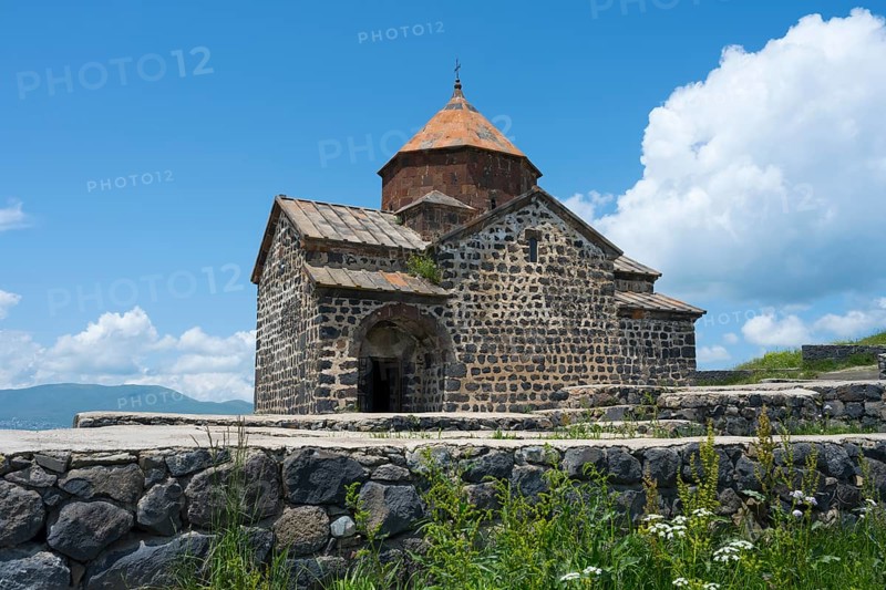 Historic stone church with orange roof against blue sky and white clouds, Sevanavank Monastery, Gegharkunik Province, Armenia