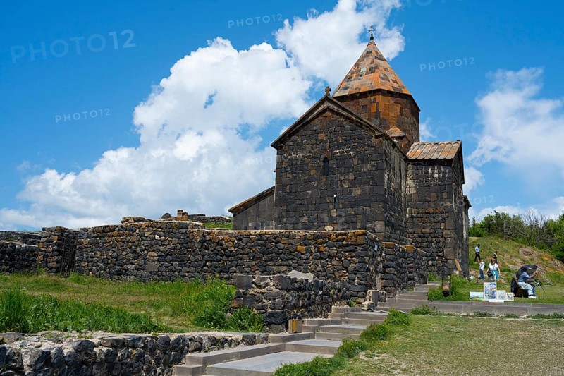 Historic stone monastery under cloudy sky in a green landscape, Sevanavank monastery, Sevan monastery, Gegharkunik province, Armenia