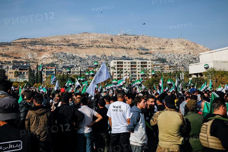 Damascus, Syria. November 28, 2025: Thousands of Syrians gather in Umayyad Square in central Damascus to celebrate the anniversary of the military operation that led to the fall of Bashar al-Assad's regime. Demonstrators express joy and unity while denouncing Israeli attacks on Syrian territory, Damascus, Damascus, Syria