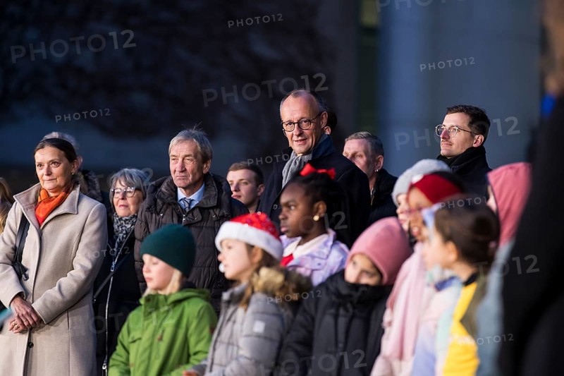 Friedrich Merz (CDU, Federal Chancellor of the Federal Republic of Germany) behind the Vocal Hero Children's Choir from Schöneberg elementary schools handing over the Christmas tree to the Federal Chancellery, Berlin, 28.11.2025