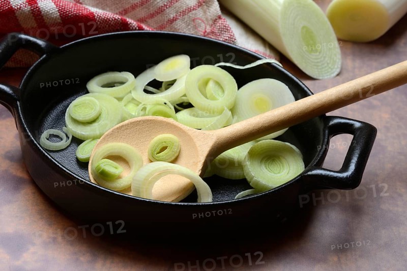 Leeks, leek rings in pan with cooking spoon, leek