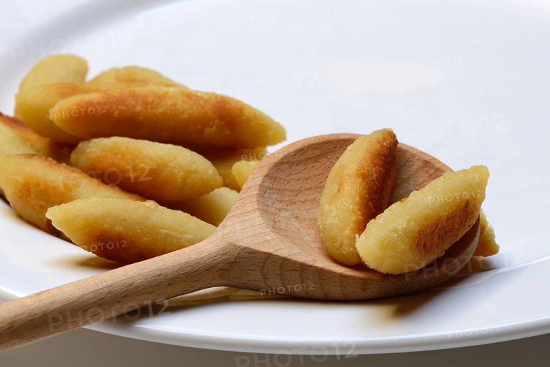 Fried puff noodles with cooking spoon on plate