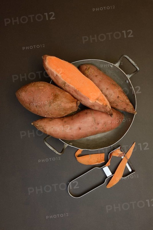 Sweet potatoes in skin with potato peeler, Ipomoea batatas