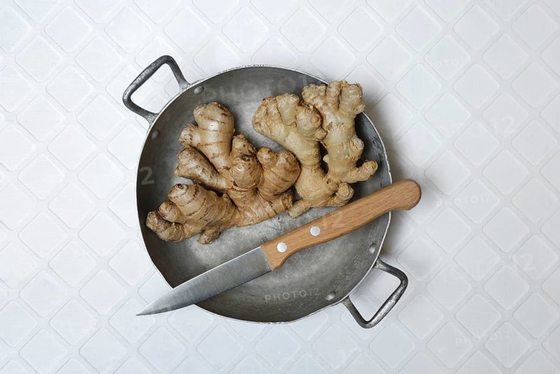 Ginger, ginger tubers in bowl with kitchen knife