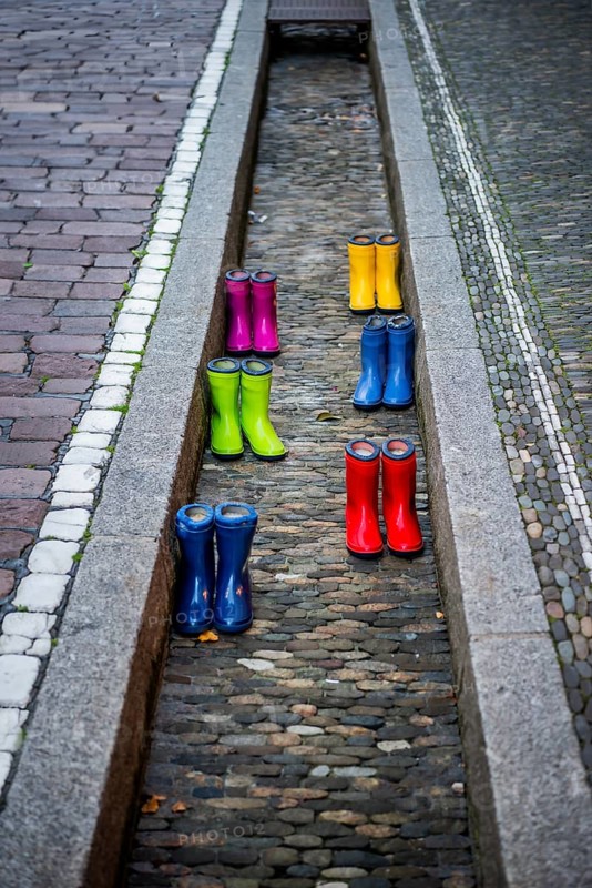 Colourful rubber boots in dry watercourse, Freiburg im Breisgau