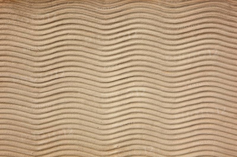 Beige sand surface with uniform wavy lines