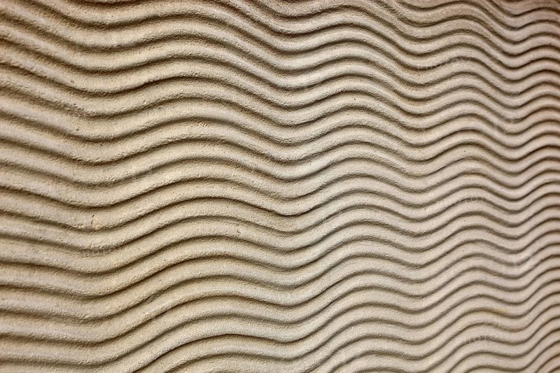 Close-up of beige sand texture with curved lines