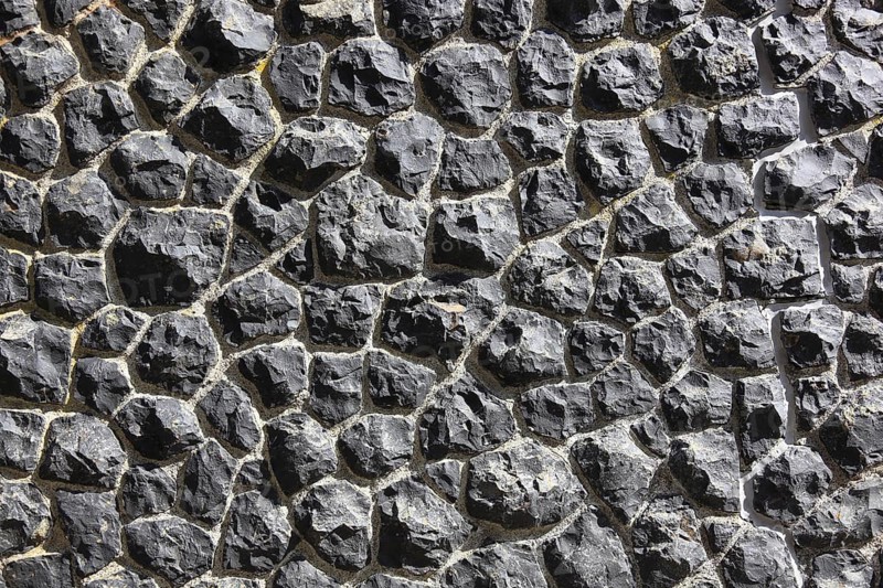 Close-up of a wall made of black textured stones