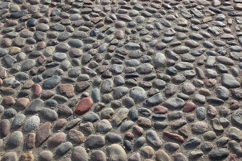 A floor of gray, round cobblestones with an uneven surface