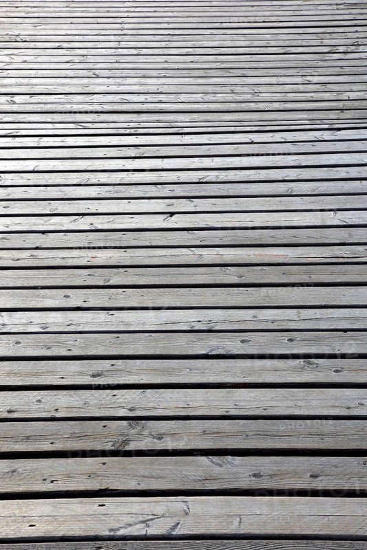 View of an expansive light gray wooden floor with parallel planks