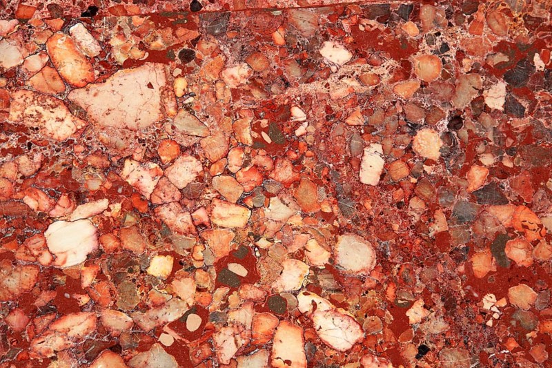 Marble surface in shades of red with diverse patterns and intensive color changes