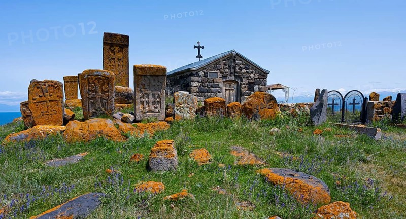 Historic chapel and tombs with stone crosses on a grassy hill, khachkars at the chapel of the Holy Cross and cemetery near Noratus, Sarukhan, Lake Sevan, Gegharkunik province, Armenia
