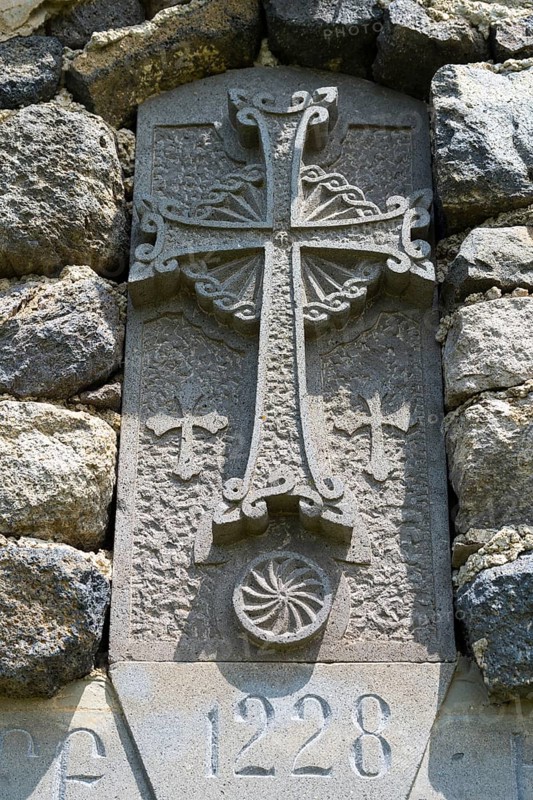 Historic stone cross with engravings and decorated architecture embedded in a stone wall, Chapel of the Holy Cross, Sarukhan, Lake Sevan, Gegharkunik Province, Armenia