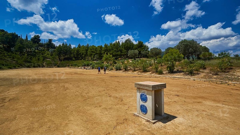 Open antique stadium with surrounding trees under a sunny sky, Ancient Stadium, Nemea, Peloponnese, Greece