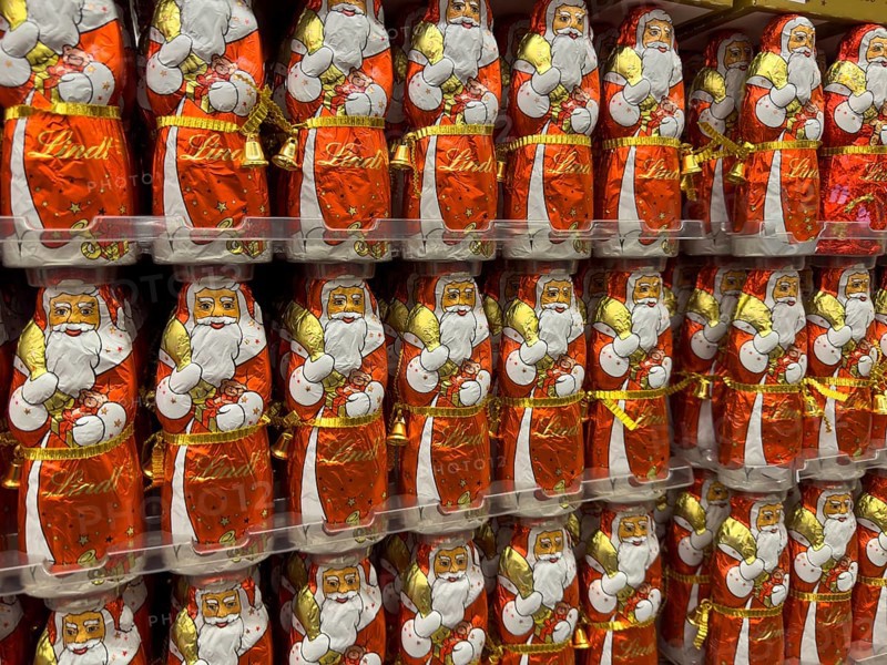 Display on the shelf of chocolate Santa Claus chocolate Santa Claus Santa Claus Santa Claus Santa Claus chocolate Santa Claus chocolate Santa Claus chocolate lice Santa Claus chocolate lice Santa Claus in color red of red staniol paper made of chocolate arranged like army of Santa Claus, Germany