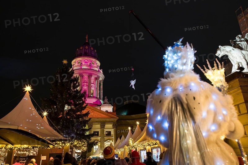 A Black-winged Stilt walker watches an artist hovering on a crane in front of the German Cathedral at the Christmas market WeihnachtsZauber Gendarmenmarkt on the Gendarmenmarkt, Berlin, 24.11.2025