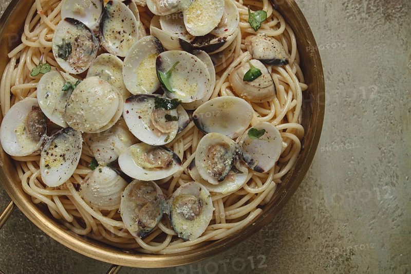 Spaghetti with vongole clams, in cream sauce, carbonara, in a brass pan, homemade, top view, no people