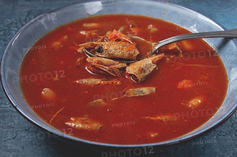 French shrimp bisque soup, in a plate, on a blue background, close-up, no people
