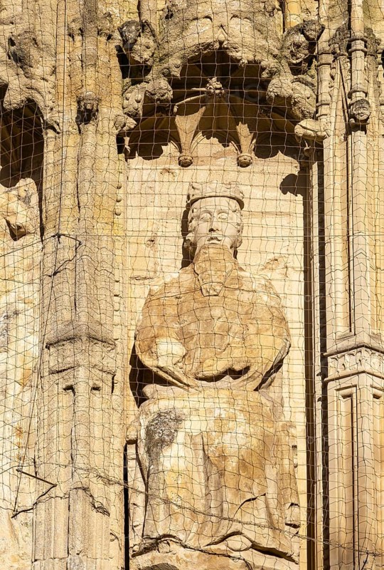 Carved stone figure of king on West Front of Exeter cathedral church, Exeter, Devon, England, UK