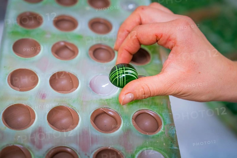 Hand holding green chocolate candy with white stripes from a chocolate mold, Christmas baking, Haselstaller Hof, Wildberg, Calw district, Germany