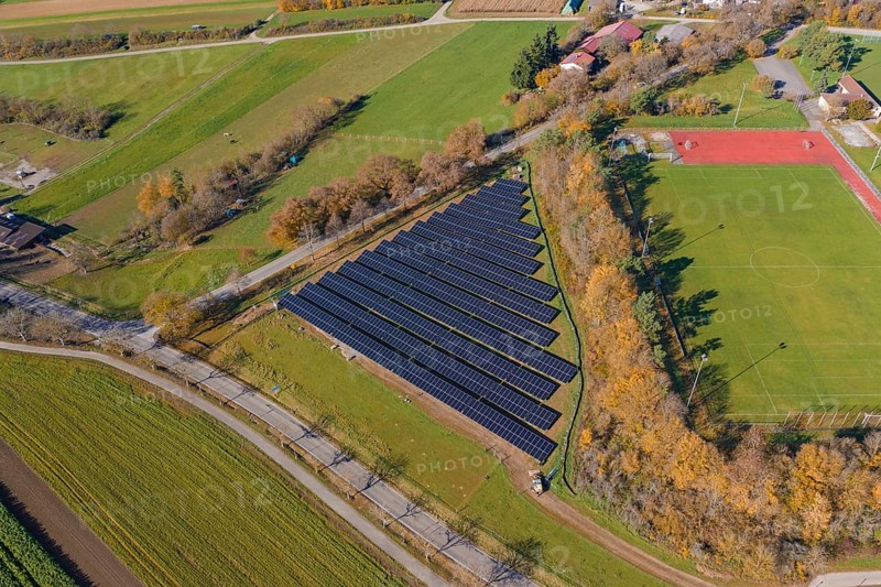 Aerial view of a solar system next to a soccer field in a rural autumn landscape, PV Freifaechenanlage construction, Weil der Stadt, Germany
