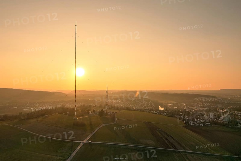 A sunset over countryside and fields with a distinctive transmission tower in the foreground, MÃ¼hlacker, Enzkreis, Germany