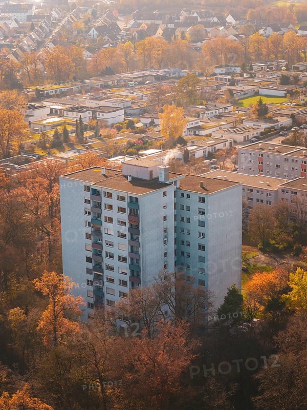 Large apartment block surrounded by autumn trees from above in an urban area, MÃ¼hlacker, Enzkreis, Germany