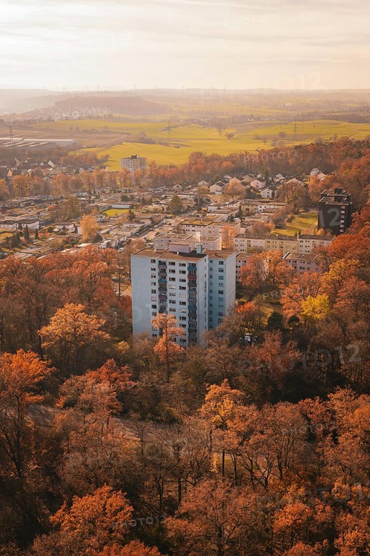 Block of flats surrounded by autumnal forest and fields close to the city in soft light, MÃ¼hlacker, Enzkreis, Germany