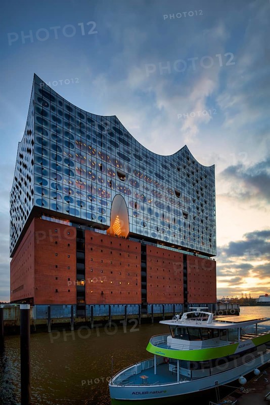 Excursion boat in front of the glass faÃ§ade of the Elbe Philharmonic Hall, Elphie, plaza, viewing platform, terrace, Free and Hanseatic City of Hamburg, evening light, Germany