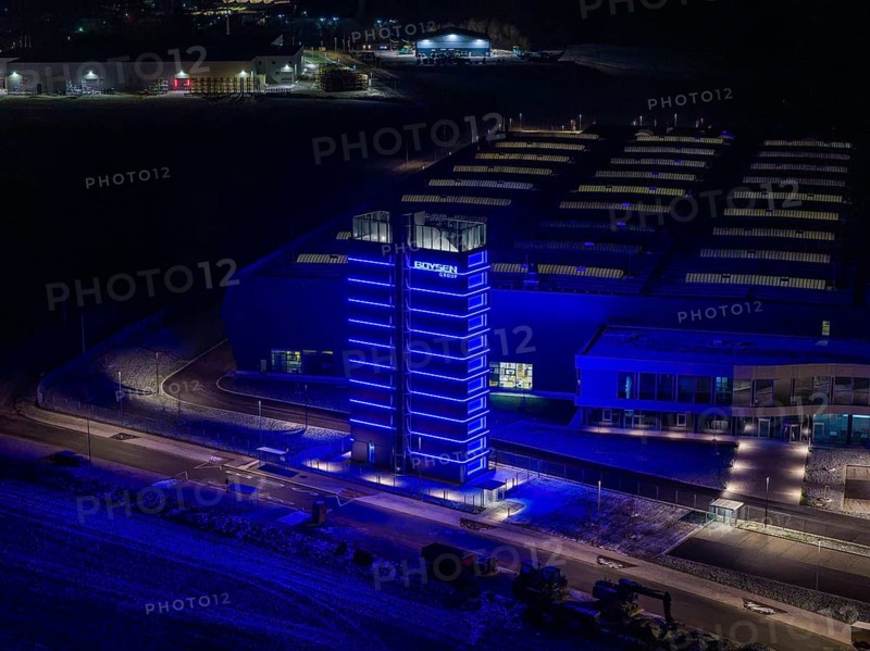 Night view of a factory with a blue illuminated tower and modern buildings, Nagold, Calw district, Germany