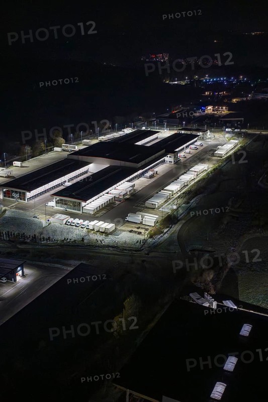 Night view of an industrial area with illuminated buildings and trucks, Nagold, Calw district, Germany