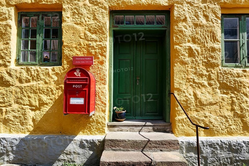 Post office, faÃ§ade detail, red mailbox with post horn and crown, green wooden door, yellow wall, ChristiansÃ¸, Christiansö, Ertholmene, Pea Islands, Bornholm, Baltic Sea, Denmark