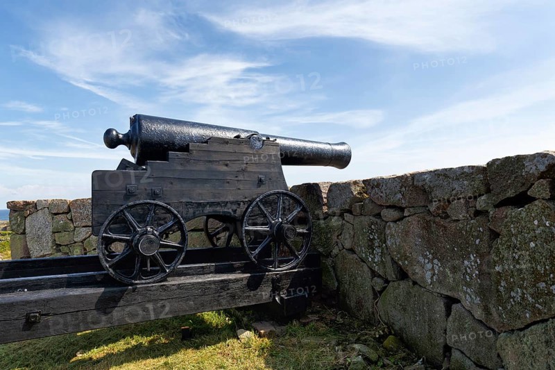 Cannon looking over stone wall at the sea, fortress, Kongens Bastion, Königsbastion, ChristiansÃ¸, Christiansö, Ertholmene, Pea Islands, Bornholm, Denmark