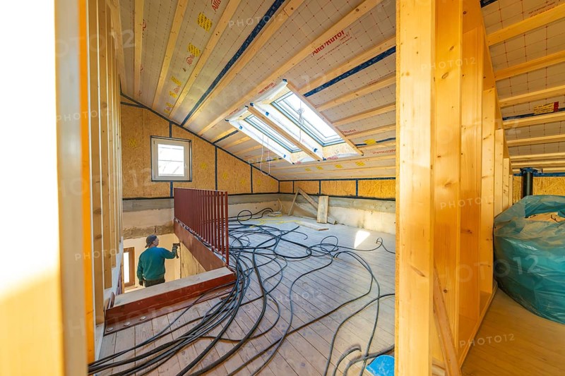 Top floor during renovation with cable harnesses and skylights that illuminate the room