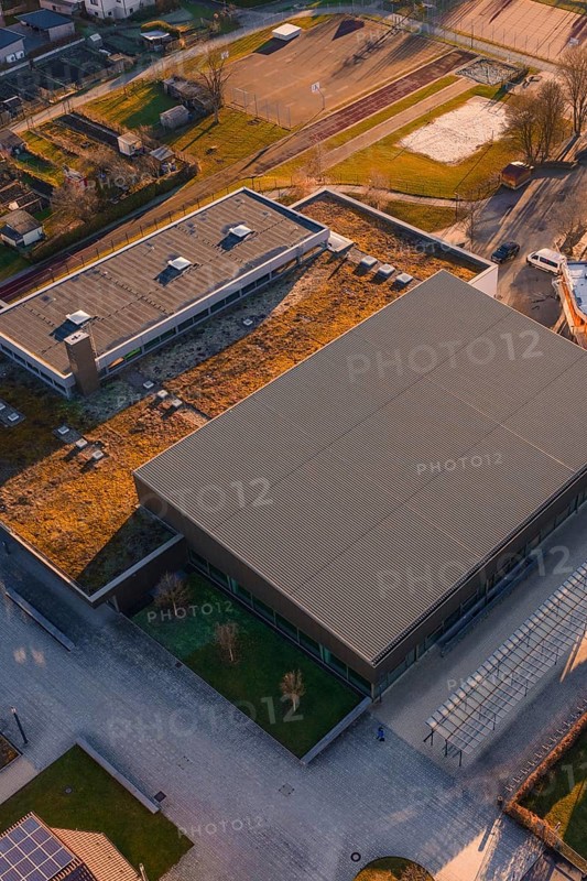 Sports center and swimming pool with flat roof and adjacent parking lot, surrounded by green areas and city limits, Althengstett, Calw district, Germany