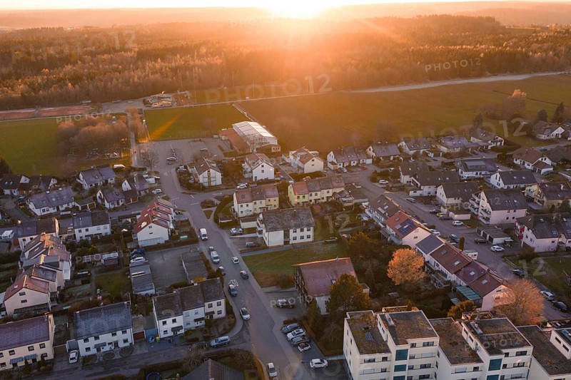 Suburb from the air with roads and cars in the evening sun, surrounded by nature, Althengstett, Calw district, Germany