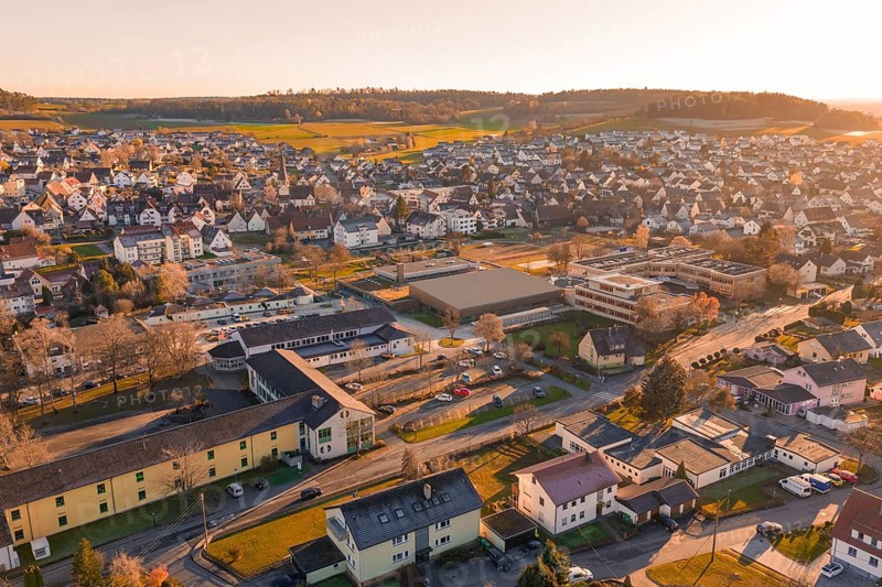 Aerial view of a settlement in warm evening light with hills and landscape in the background, Althengstett, Calw district, Germany