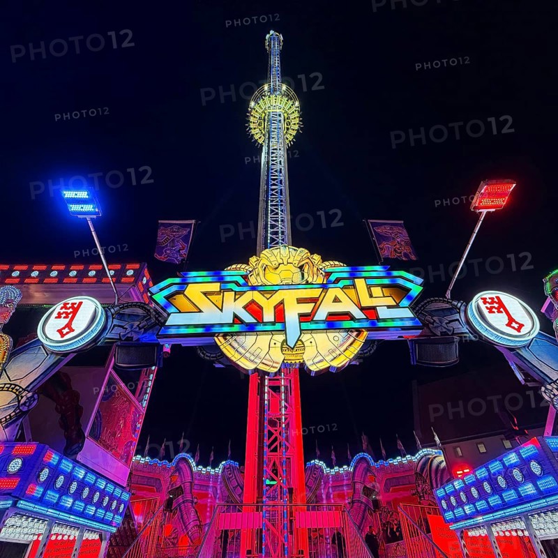 Colourfully illuminated Skyfal free fall tower at night at the All Saints Fair, Soest, North Rhine-Westphalia, Germany