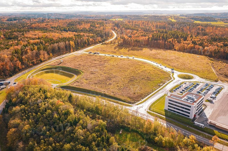 Industrial site with parking lot and adjacent forest in an autumn setting, new Lindenrain industrial park, Calw, Black Forest, Germany