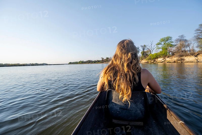 Tourists in a Mokoro, dugout boat on the Okavango River, Caprivi Strip, Namibia