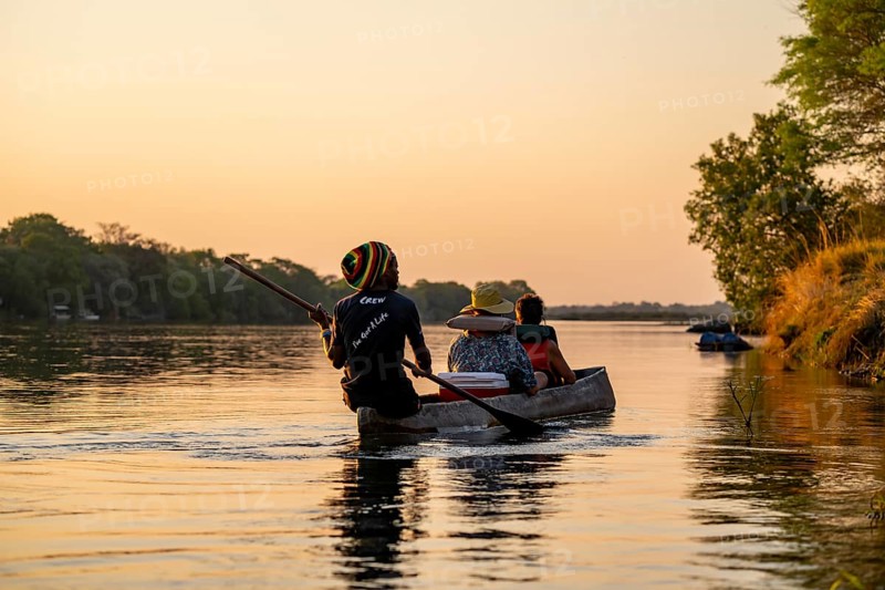 Sunset boat trip, tourists in a Mokoro, dugout boat on the Okavango River, Caprivi Strip, Namibia