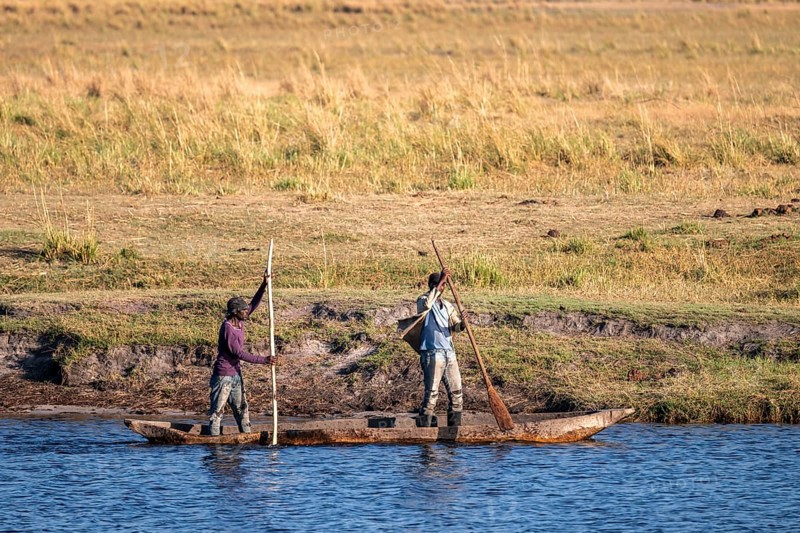 Locals with dugout boat in Chobe River, Ihaha, Chobe National Park, Botswana