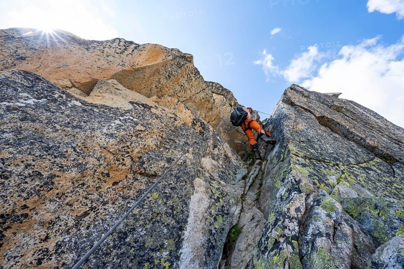 Mountaineers on steep rock face in the secured via ferrata Crocodile Mountain Lake at Bergseeschijen-Vorbau, Sonnenstern, Göscheneralp, Canton of Uri, Switzerland