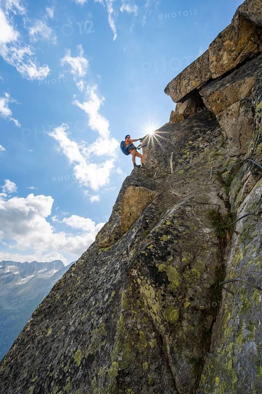 Female mountaineer on steep rock face on the secured via ferrata Krokodil-Bergsee am Bergseeschijen-Vorbau, Sonnenstern, Göscheneralp, Canton of Uri, Switzerland