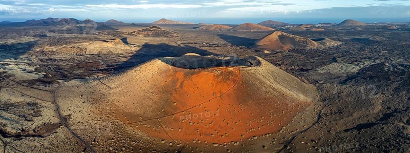 Caldera Colorada volcano, picturesque volcanic landscape with volcanic craters and lava fields in morning light, Parque Natural de Los Volcanes, aerial view, Lanzarote, Canary Islands, Spain