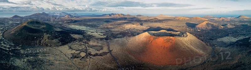 Caldera Colorada volcano and MontaÃ±a Negra, picturesque volcanic landscape with volcanic craters and lava fields in morning light, Parque Natural de Los Volcanes, aerial view, Lanzarote, Canary Islands, Spain